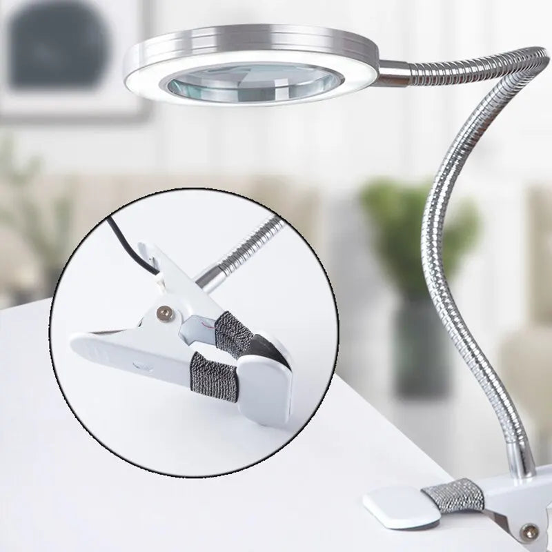 Flexible table lamp with magnifying glass.